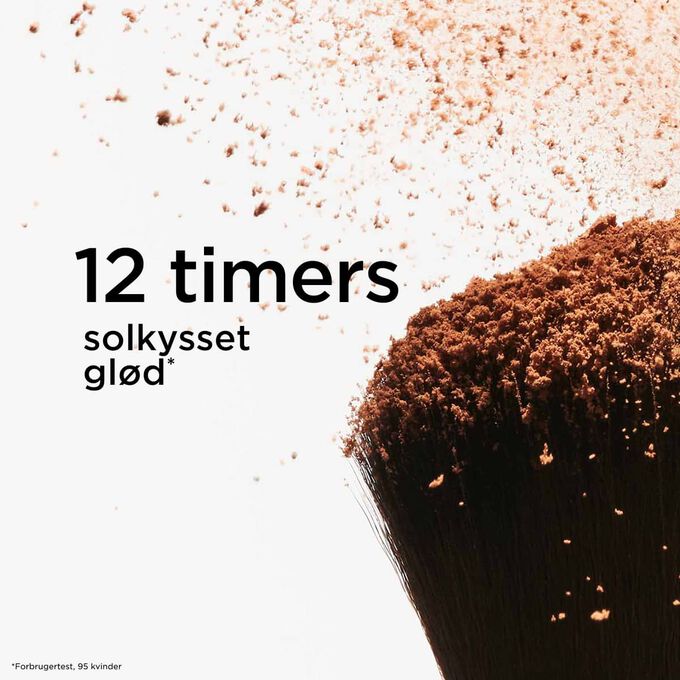 Fokus p&aring; toppen af en pudderb&oslash;rste, der spreder bronzingpudder og illustrerer dens 12-timers solkysset effekt for en str&aring;lende finish