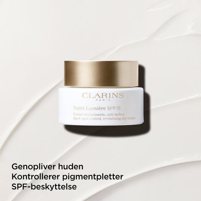Dagcreme mod pigmentpletter med SPF 15 p&aring; en tekstureret baggrund, der fremh&aelig;ver dens genoplivende effekt p&aring; huden