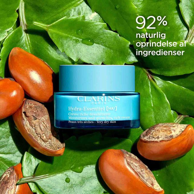 Packshot of Clarins Hydra-Essentiel 23 Rich Cream among leaves and shea nuts, highlighting its 92% natural origin ingredients