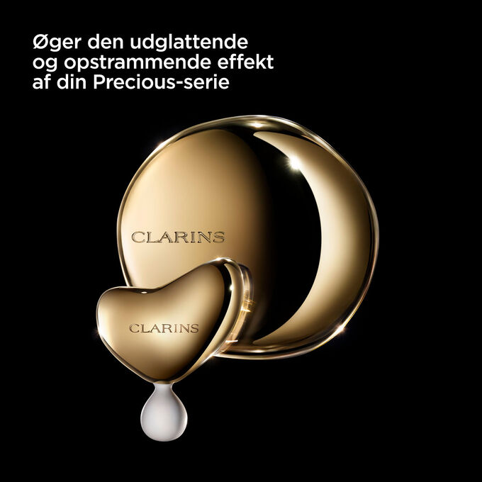 Photoshoot of Clarins Massage Tool on dark background, with text emphasising its utility for the Precious range.