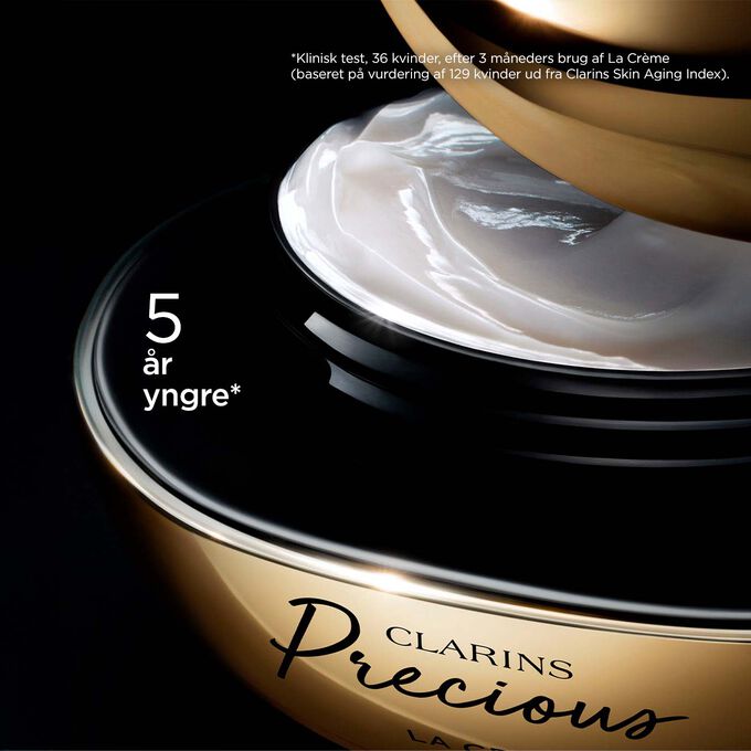 Packshot of Clarins Precious Soft Cream on dark background, with text emphasising its power to make skin appear 5 years younger