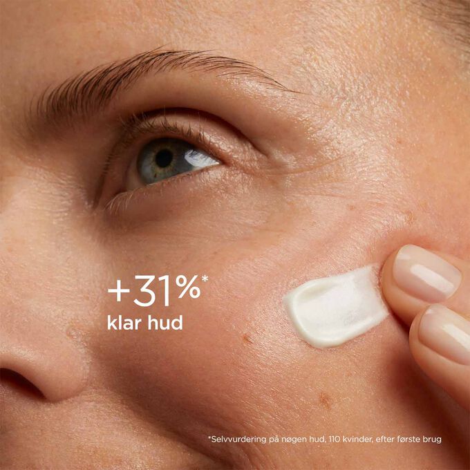 Woman with closed eyes, wearing SOS Primer White by Clarins on her face to illustrate that it reduces signs of fatigue by 20%