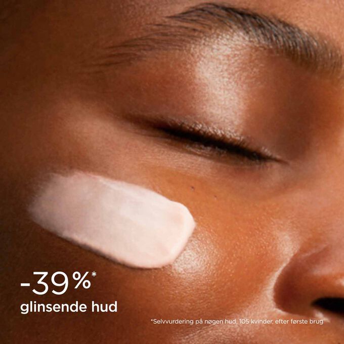 Woman with closed eyes, wearing SOS Primer Mattifying by Clarins on her face to illustrate that it reduces skin shine by 39%.