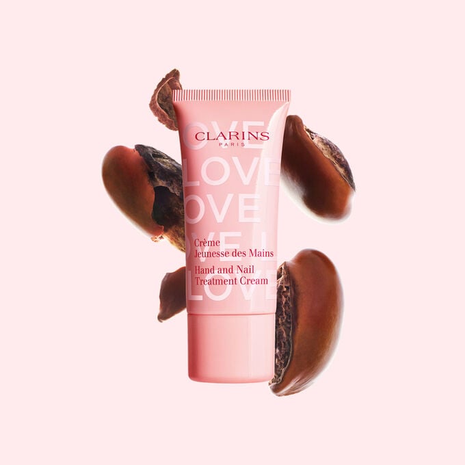 Packshot af Hand Cream Limited Edition Love Collection foran sheafr&oslash; p&aring; en lyser&oslash;d baggrund, der fremh&aelig;ver den centrale n&oslash;gleingrediens.
