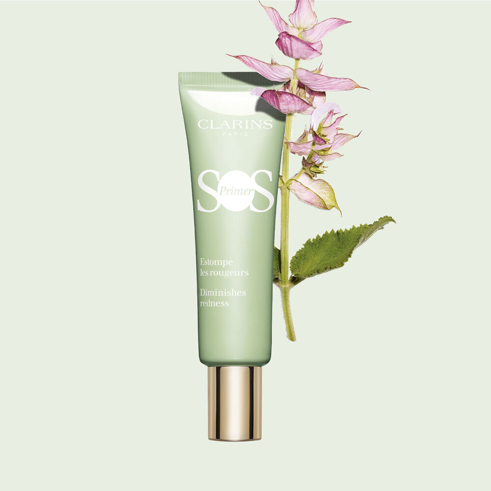 Packshot of a tube of SOS Primer Green by Clarins to reduce the appearance of redness, with a branch of clary sage