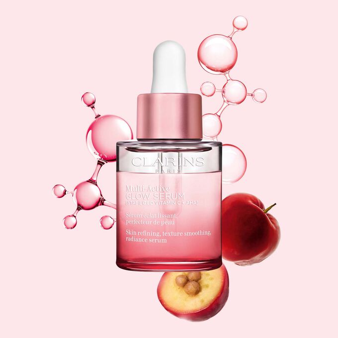 Packshot af Multi-Active Glow Serum med C-vitaminmolekyle og acerola p&aring; en lyser&oslash;d baggrund, fremh&aelig;ver hudens gl&oslash;d.